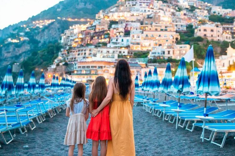 Famiglia abbracciata sulla spiaggia della costiera amalfitana guardando verso positano