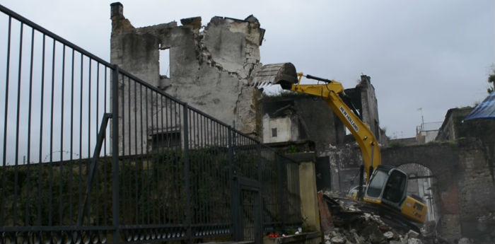 photos of a bulldozer at work to remove debris from the collapse of a wall at San Giovanni a Teduccio