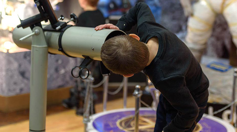 Child at the telescope. Christmas in the City of Science