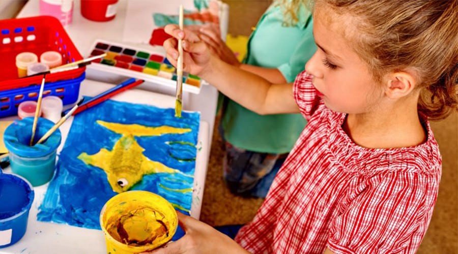 Niña usando colores para dibujar