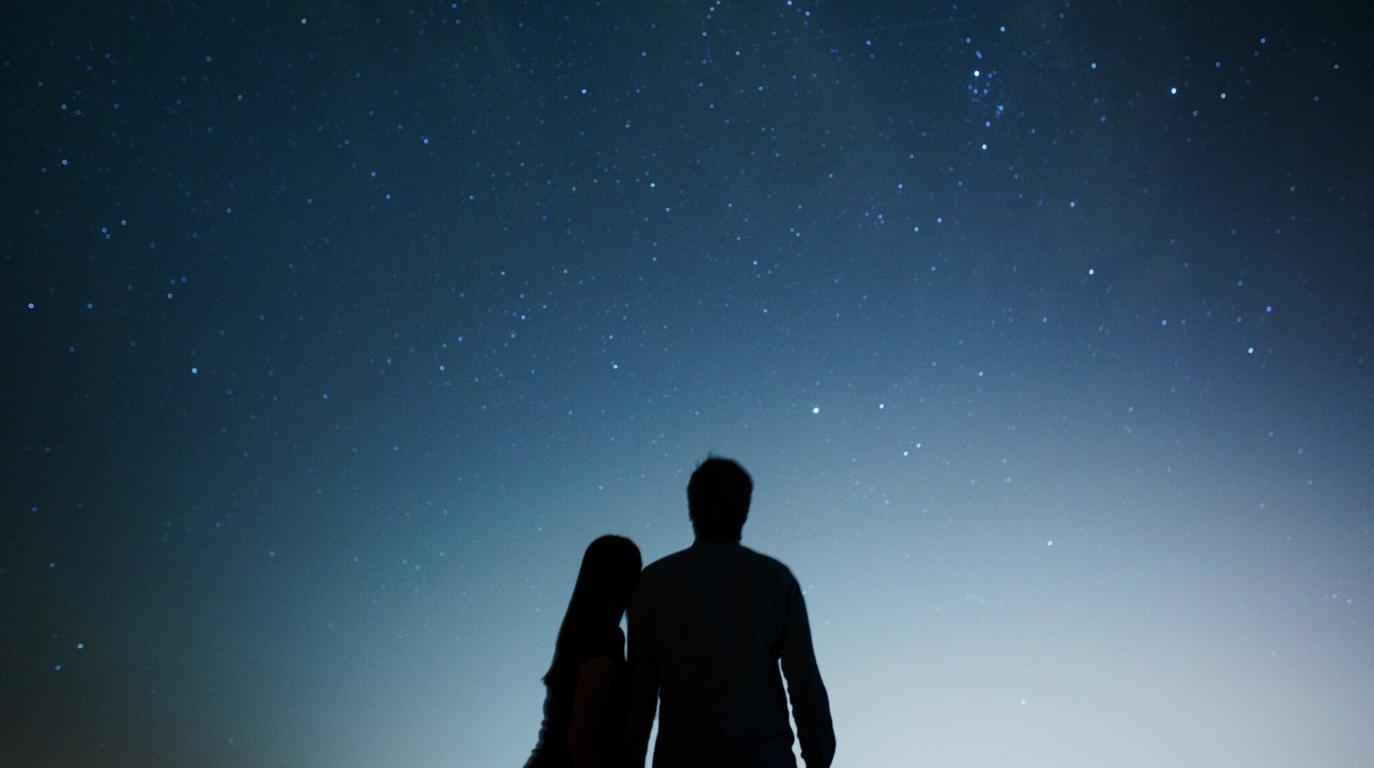 Casal olhando o céu estrelado