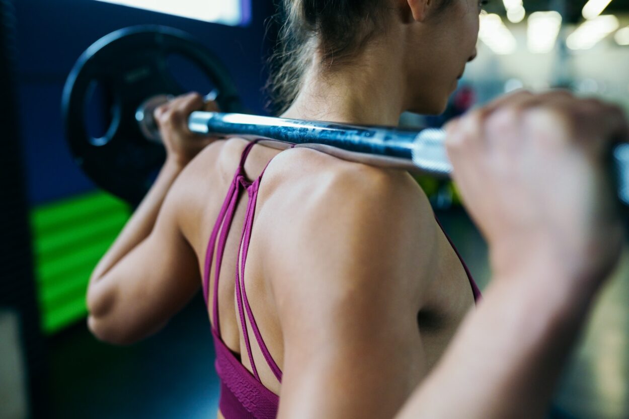 Athletische Frau im Fitnessstudio beim Heben von Gewichten im Fitnessstudio