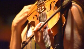 Músico con violín en cálida luz dorada