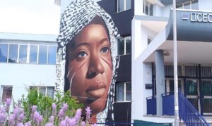 Wandmalereien von Jorit in Ischia, auf einer Schule das Gesicht einer Afrikanerin