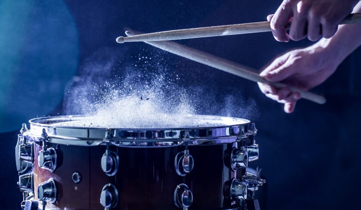 Man plays musical percussion instrument with sticks.