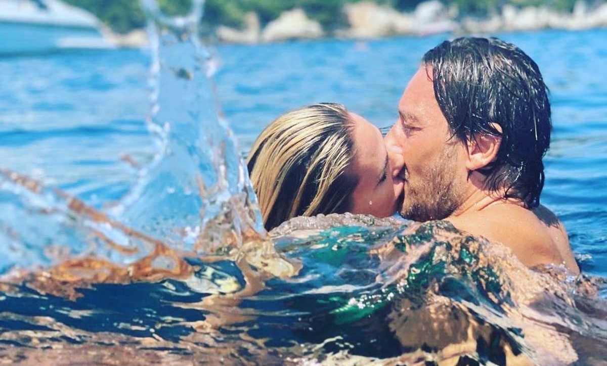 Francesco Totti e Ilary Blasi se besan en el agua