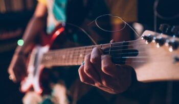 Close up young woman musician playing electric guitar