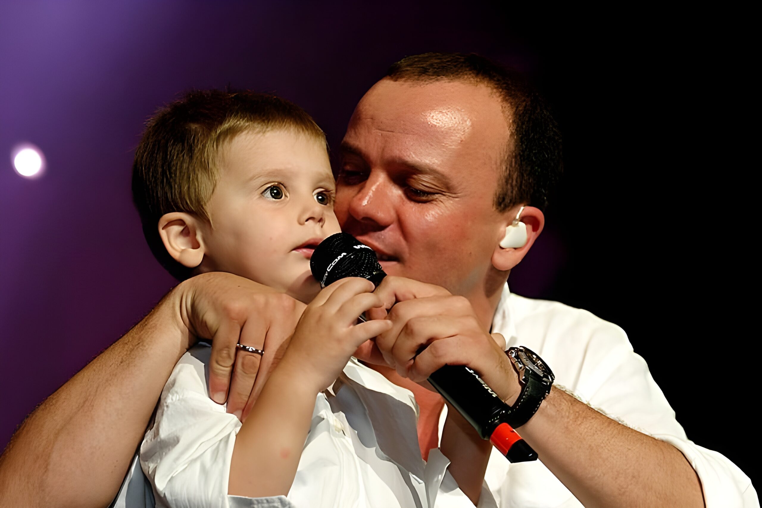 Gros plan de Gigi D'Alessio avec un bébé dans les bras