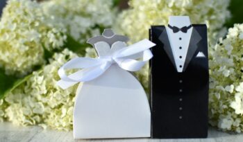 A bride and groom wedding favors in front of white hydrangeas. Generic couple