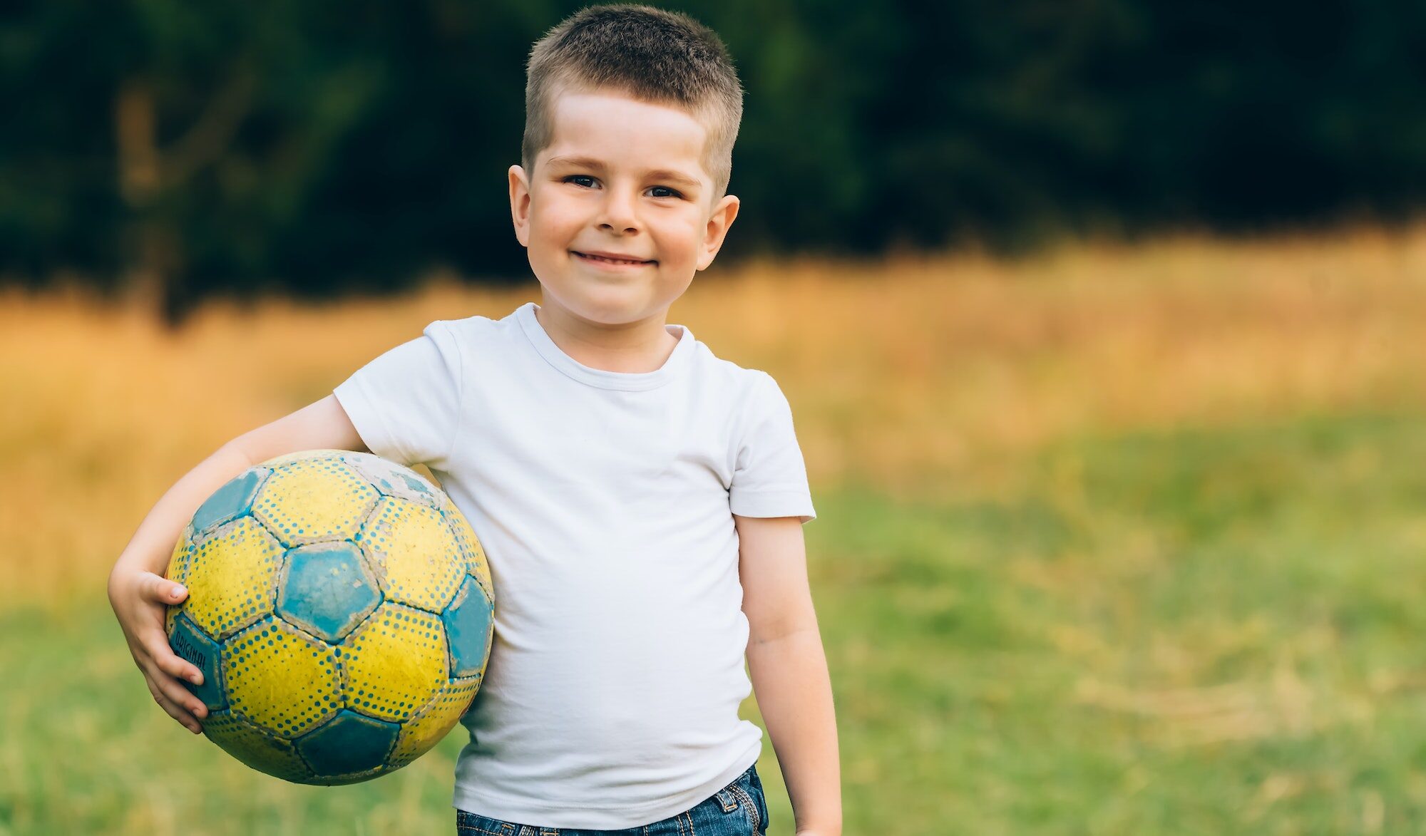 Criança com bola de futebol