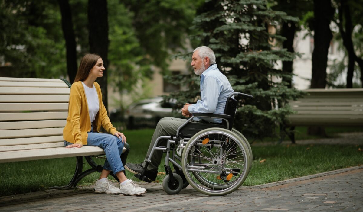 Fille et père handicapé se reposant sur un banc