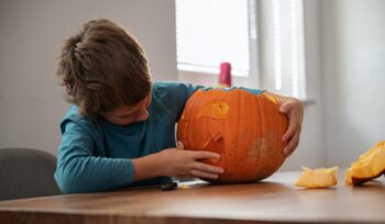 Schoolboy making his own halloween pumpkin