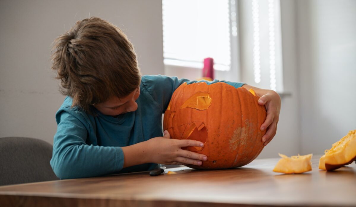 Colegial haciendo su propia calabaza de halloween