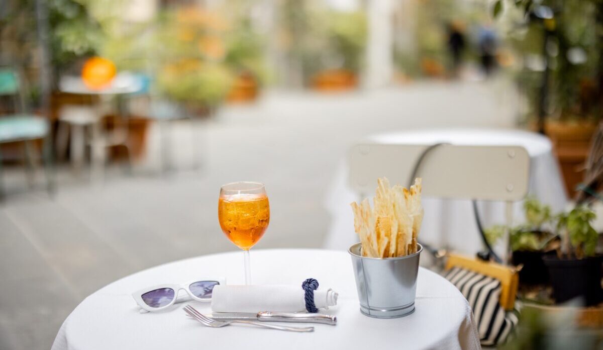 Spritzen Sie Aperol-Getränk auf einen Tisch im Freien