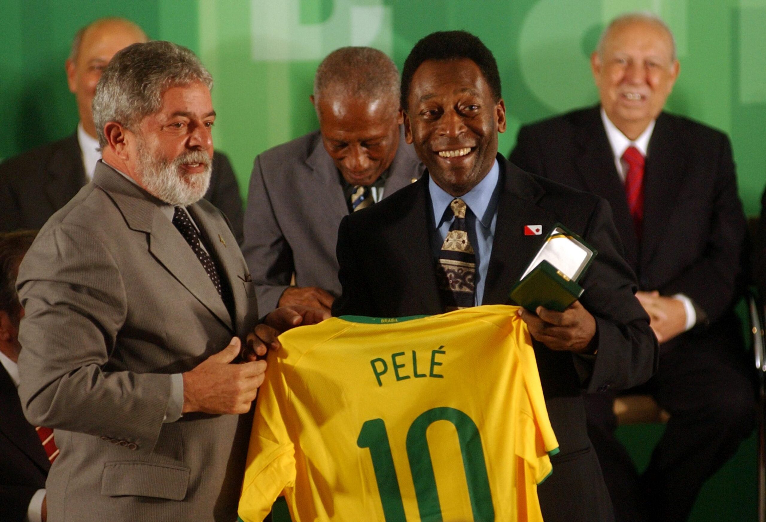 Pele and Lula in a photo where they hold the player's soccer jersey