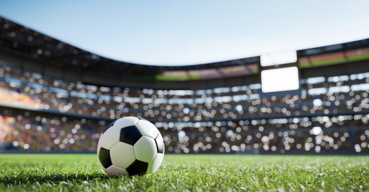 Balón de fútbol en campo de hierba en el estadio