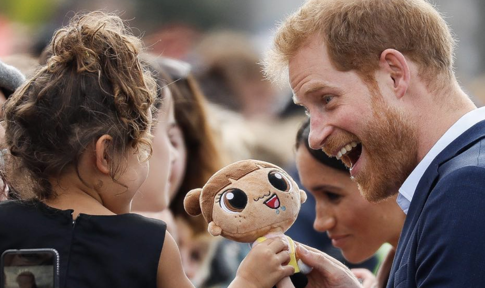 Le prince Harry souriant à une petite Anglaise dans le public