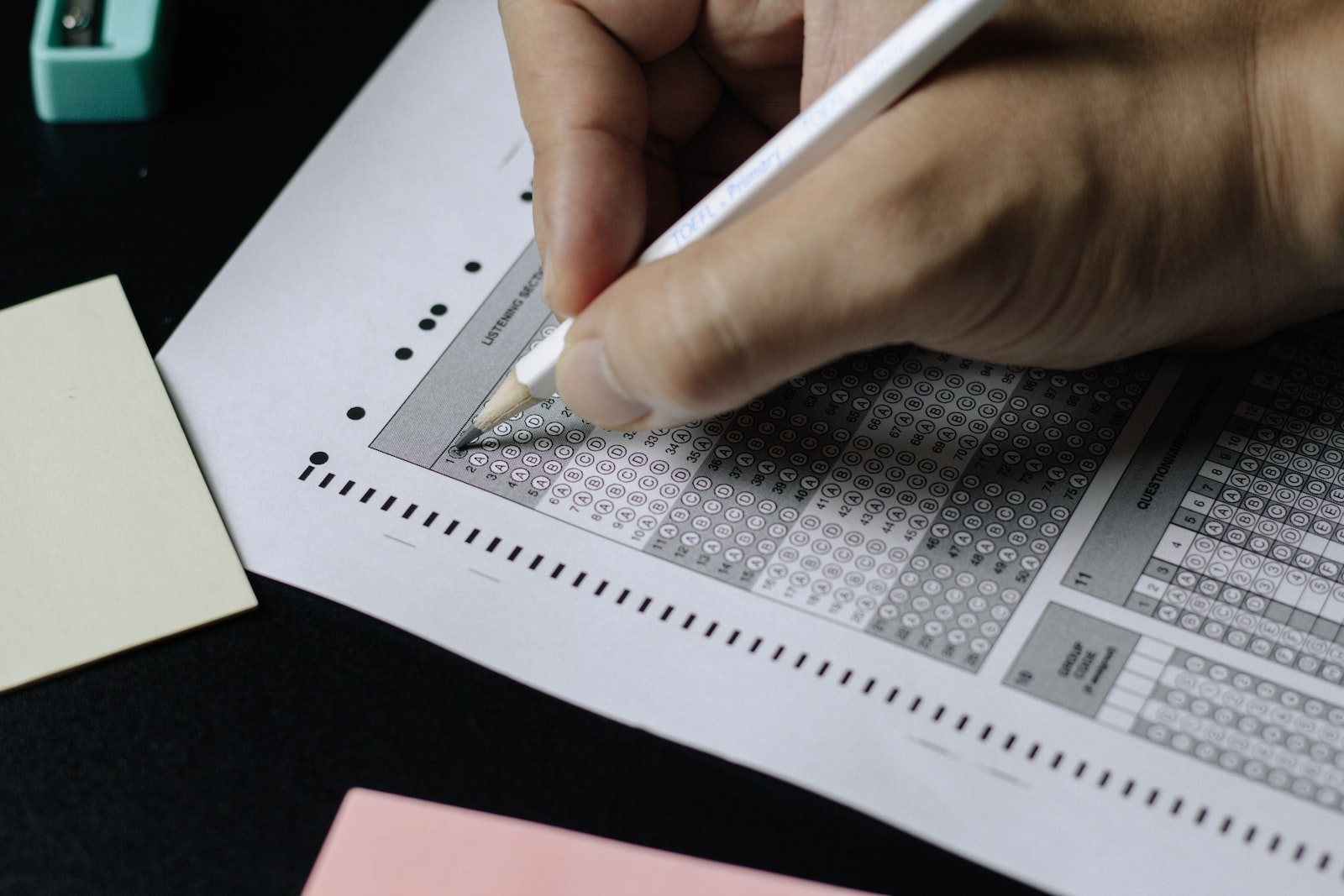 personne qui écrit sur du papier blanc