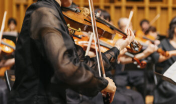 Violencellista tocando violino durante um show