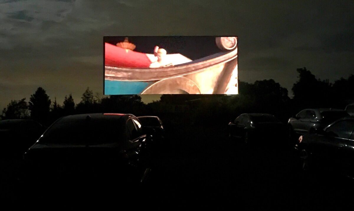 Watching a move at the drive in cinema movie theater. Safe entertainment during coronavirus, COVID