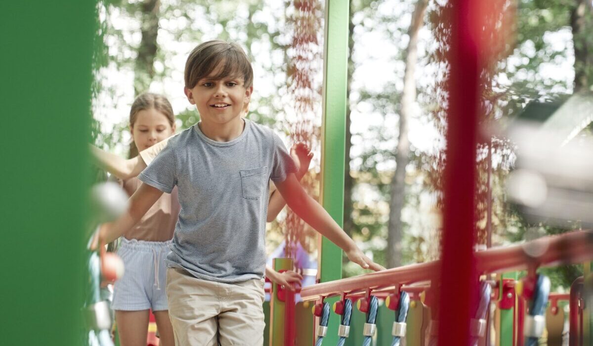 Gruppe von Kindern, die am Sommertag auf dem Spielplatz spielen