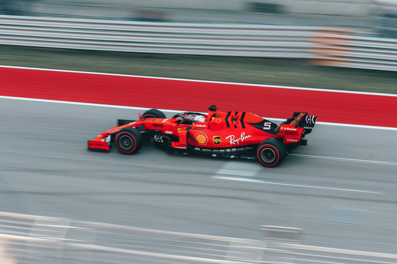 Selektive Fokusfotografie der roten Formel 1 auf der Strecke