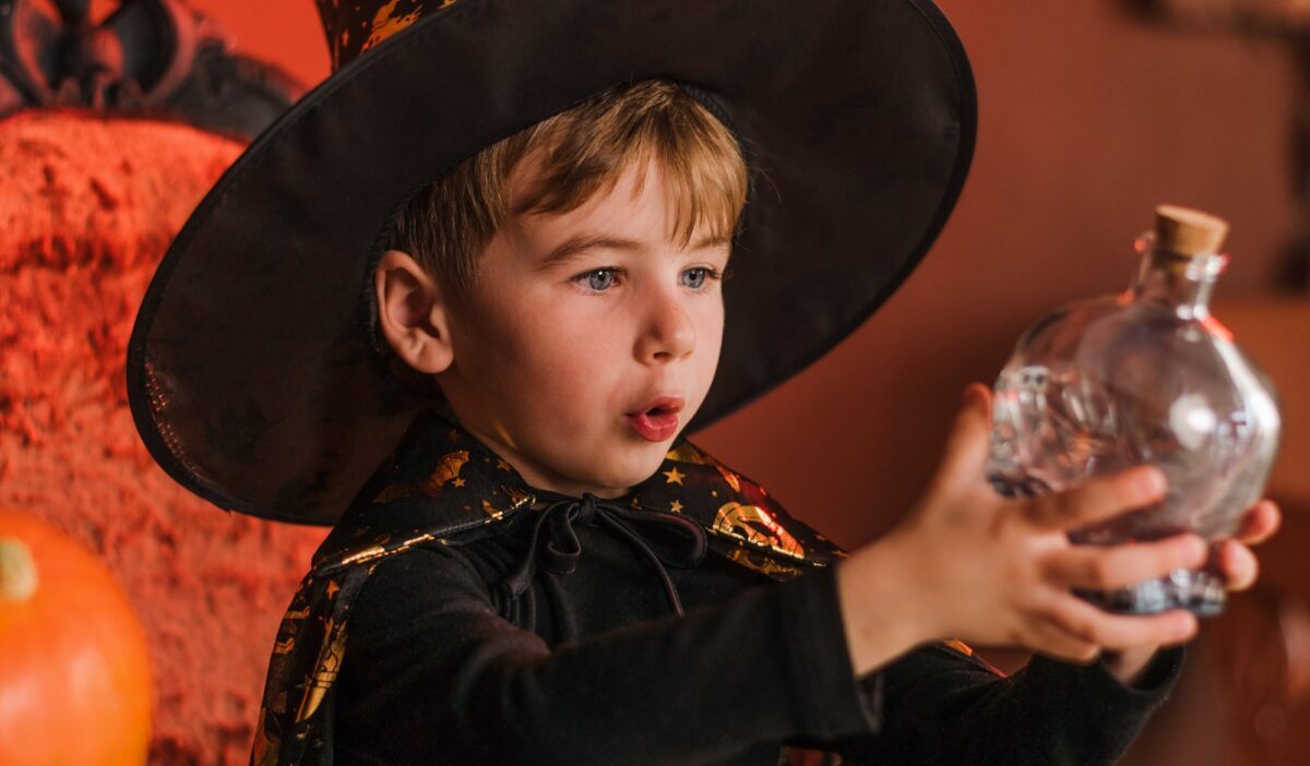 一个在万圣节化装舞会上穿着魔术师服装的小男孩。万圣节的概念。