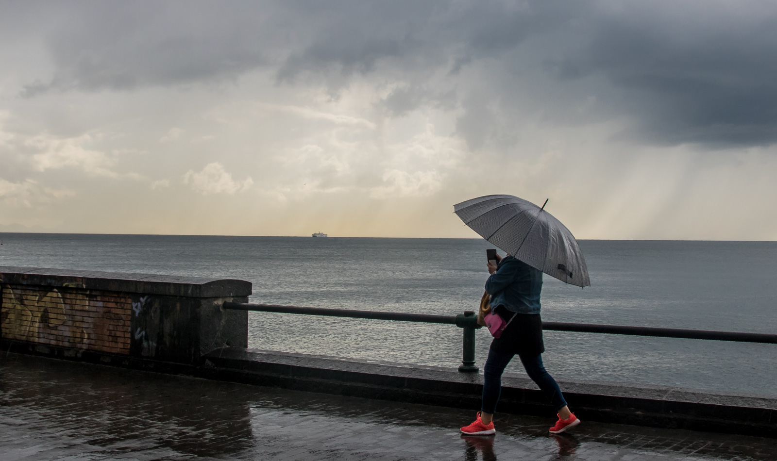 Una ragazza durante una giornata di pioggia sul Lungomare di Napoli