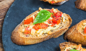 Una bruschetta de tomate con aceite de oliva y albahaca