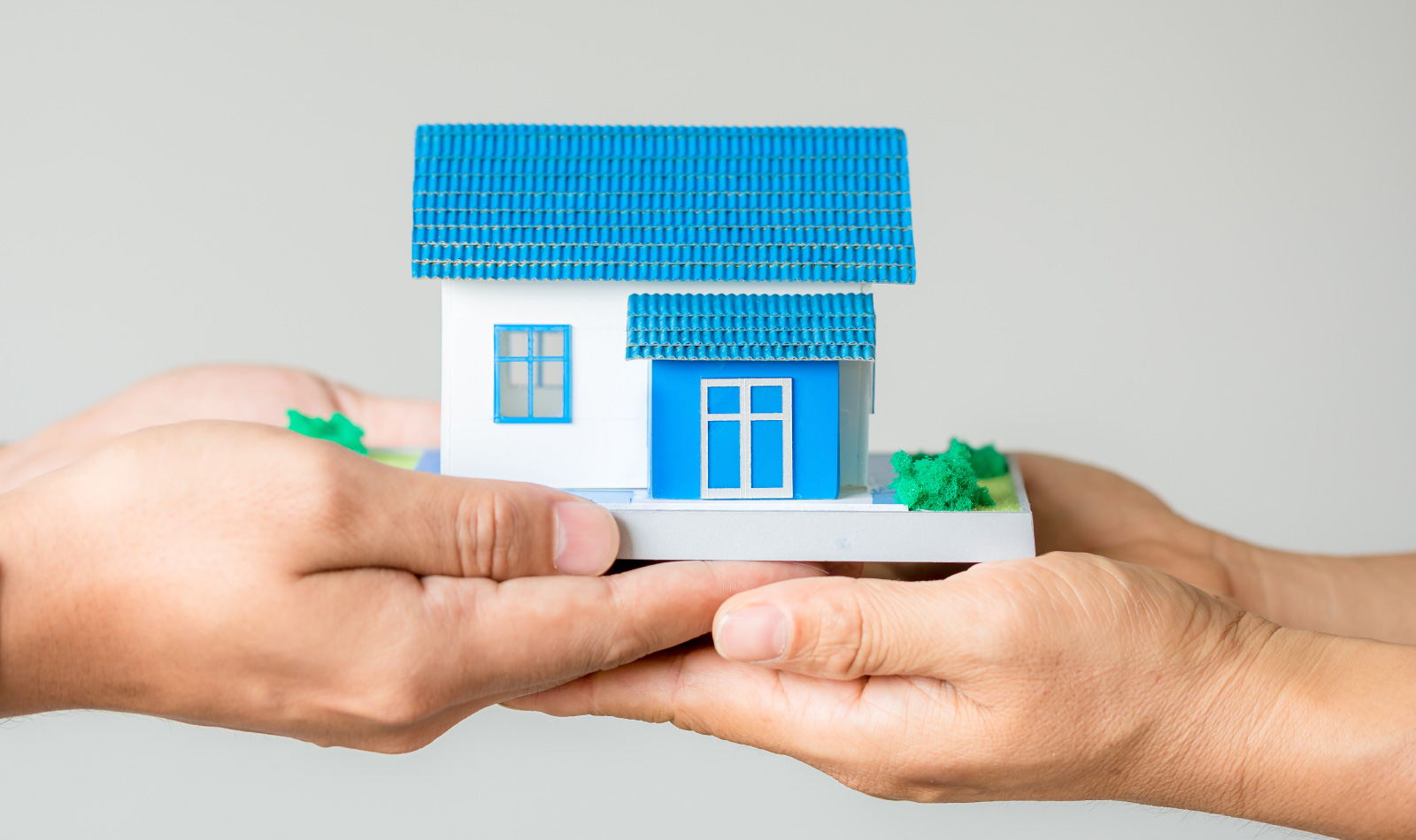 Petite maison entre les mains de certaines personnes, qui représente symboliquement prendre soin de sa maison