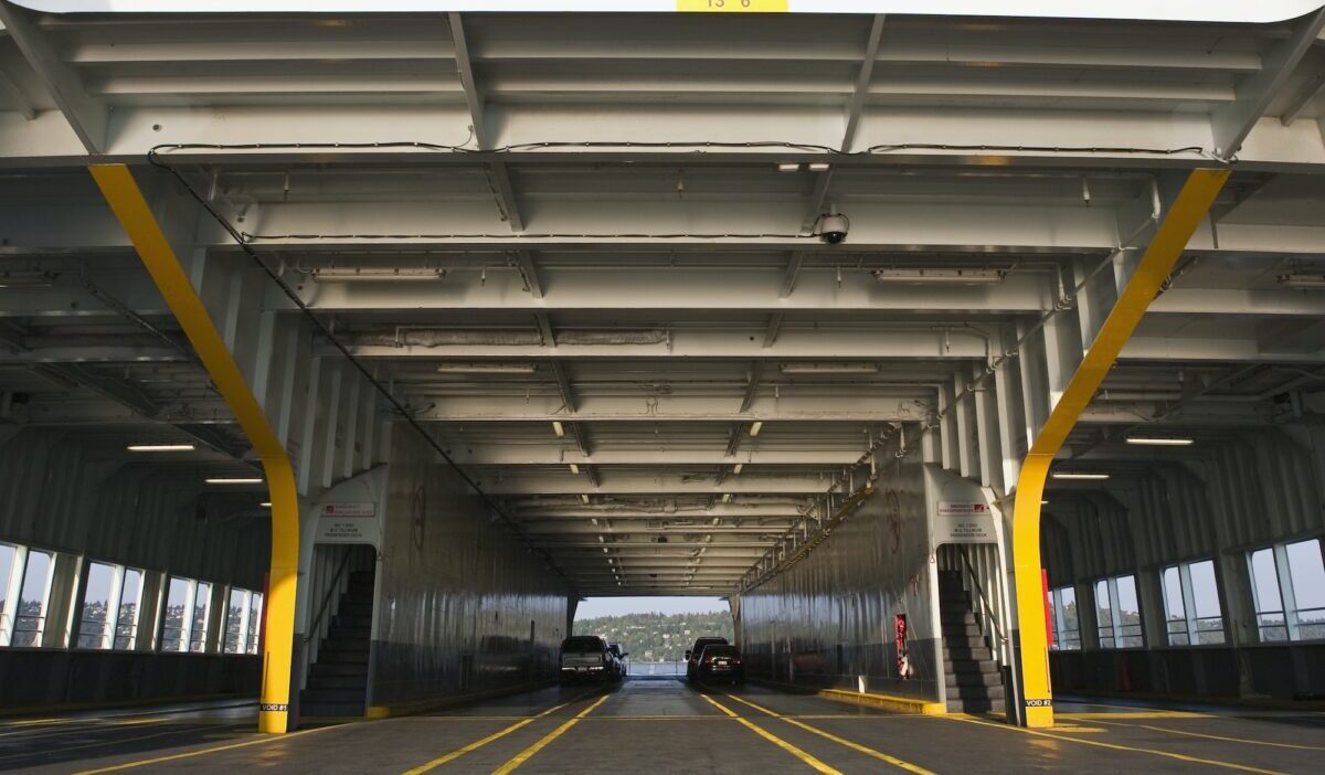 Car ferry on the water, car deck and upper deck, two cars and spaces