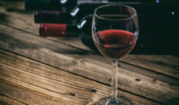 Red wine glass on wooden background