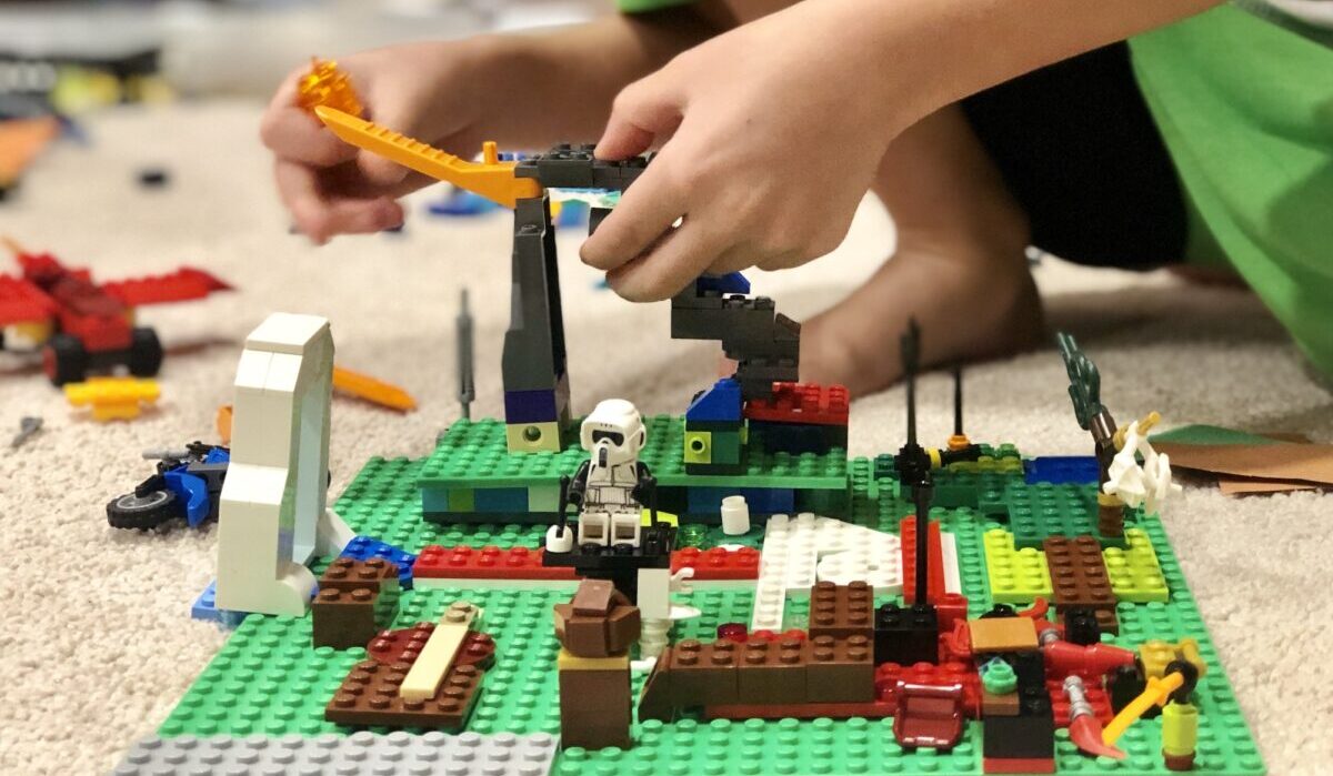 Menino brincando e construindo com brinquedos LEGO