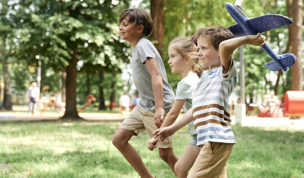 Group of kids playing together with airplane toy