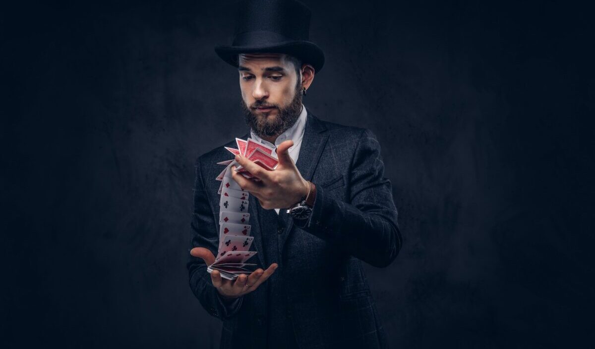 Magician showing trick with playing cards.