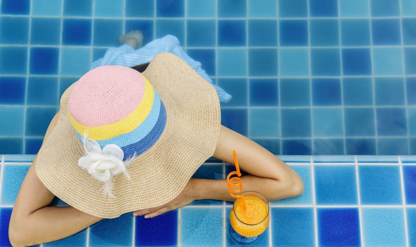 Frau entspannt sich im Schwimmbad, Sommerurlaub