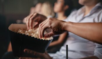 Young people eating popcorn in movie theater