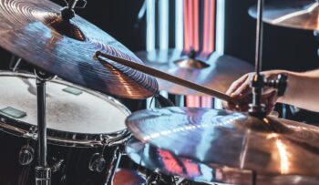 Feche o baterista toca bateria com baquetas.