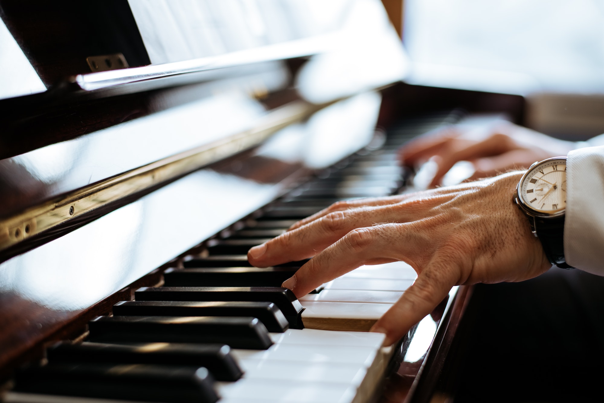 Recortar manos masculinas tocando el piano