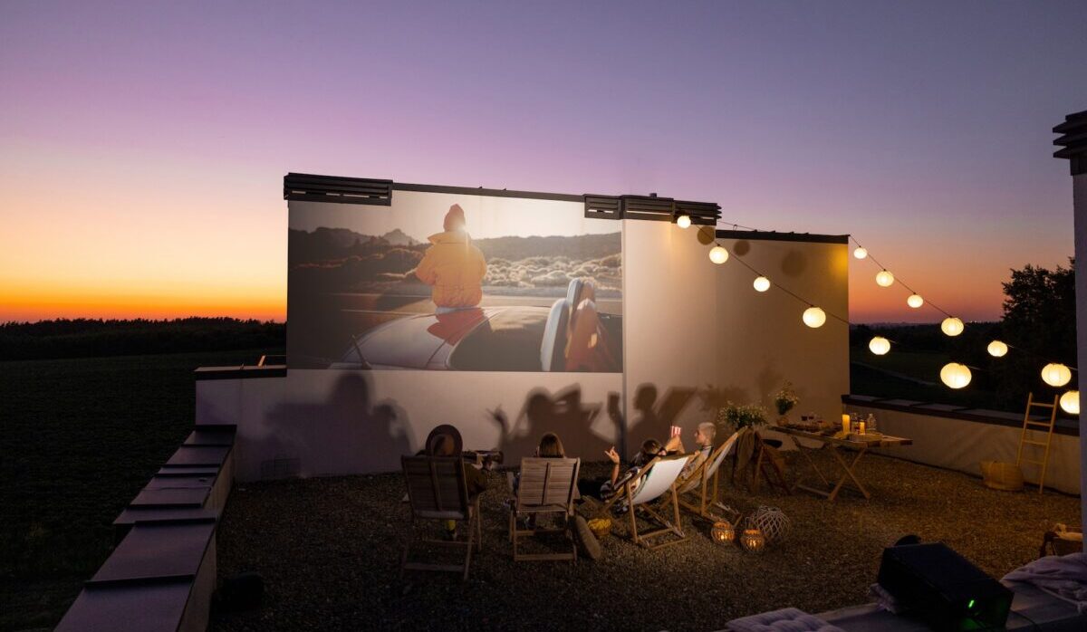 People watching movie on the rooftop terrace at sunset