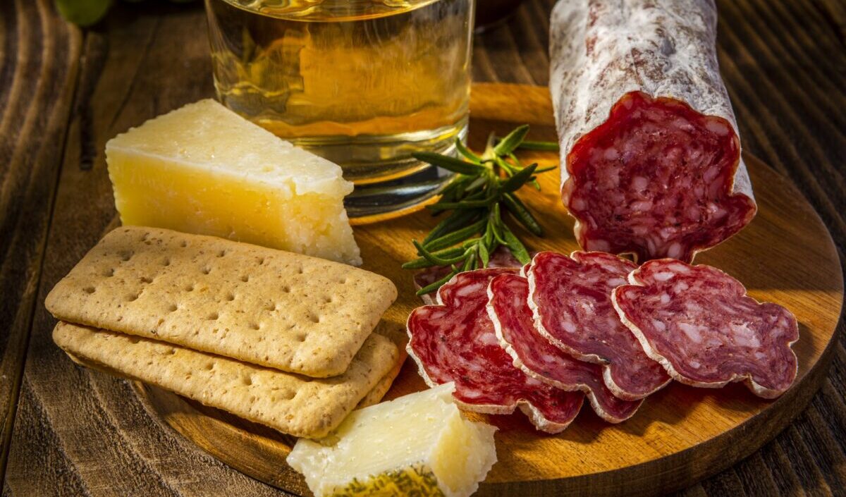 Sliced Salame on Wooden Plate with Cheese and Wine. Italian Appetizer