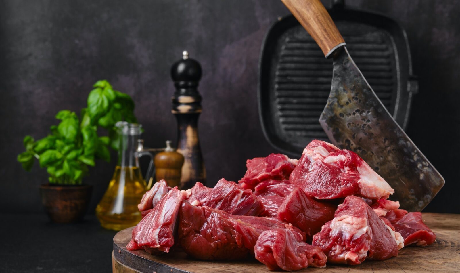 Chopping fresh beef meat on wooden chopping stump