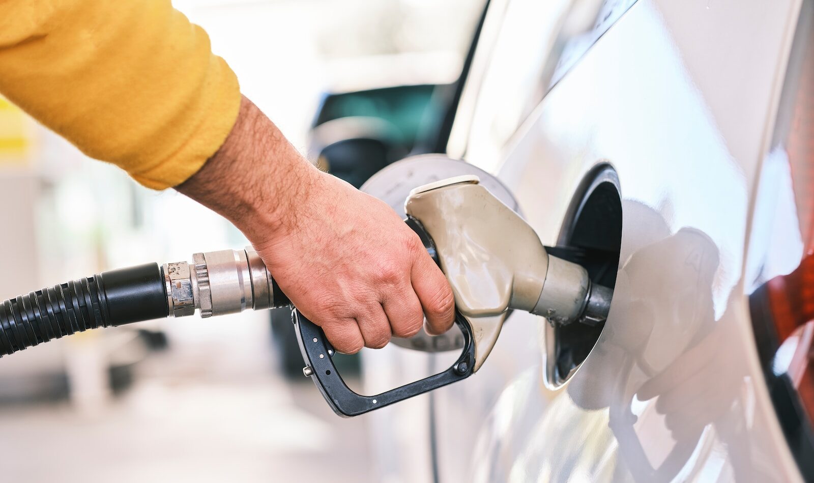 un homme pompant de l'essence dans sa voiture à une station-service