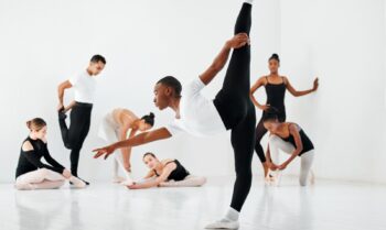 Полнометражный снимок разнообразной группы студентов балета, репетирующих в своей танцевальной студии.