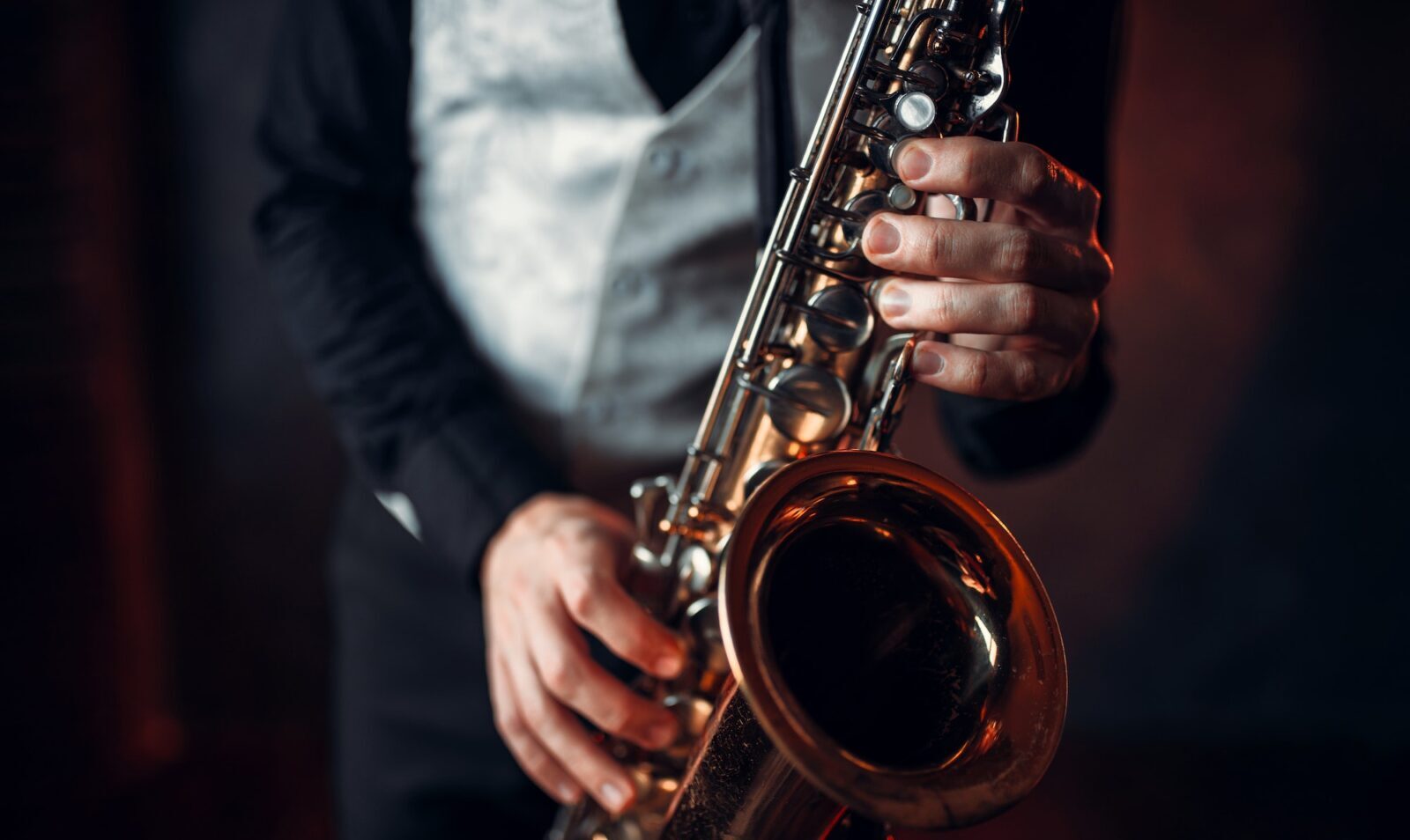 Jazz man hands holding saxophone closeup