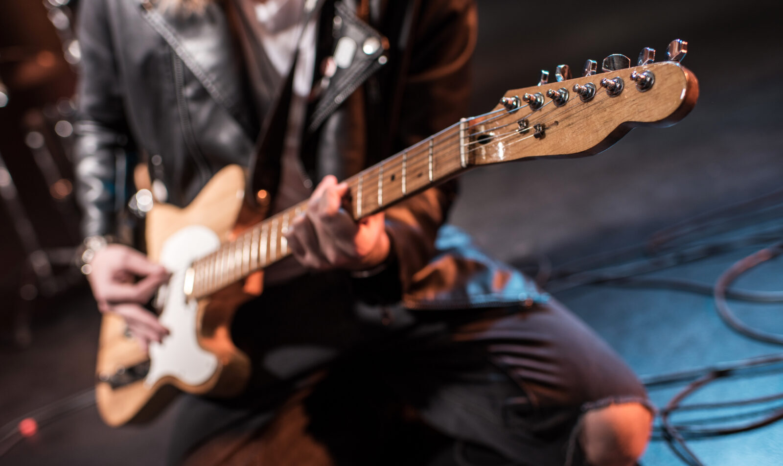 Close-up partial view of rock star playing hard rock music on stage