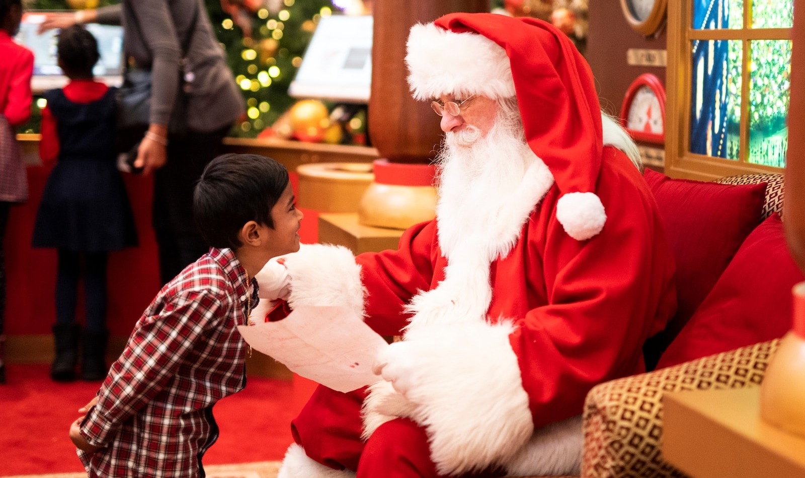 ragazzo in piedi davanti a un uomo che indossa il costume di Babbo Natale