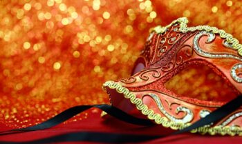 Vintage carnival mask in front of glowing background