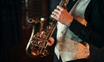 Manos de hombre de jazz sosteniendo el saxofón closeup