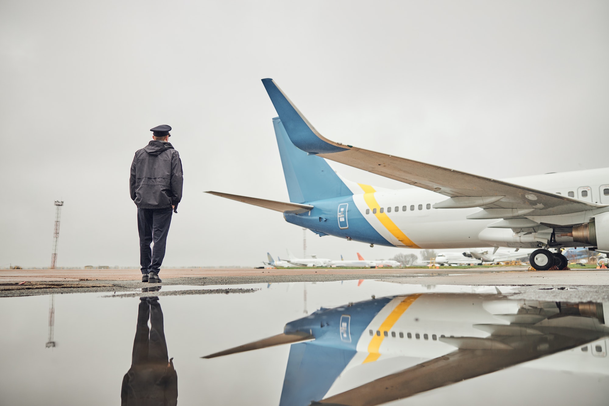 飛行機の近くの幸せな自信に満ちた白人の飛行機乗組員の肖像画